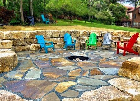 A natural stone retaining wall lining a patio.