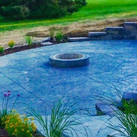 A wood burning fire pit surrounded by a custom stone patio.