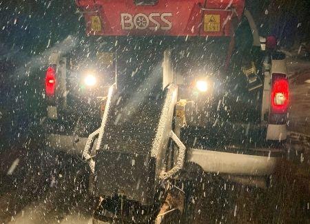 A Black Brook Lawn & Landscape truck equipped with a salt spreader for de-icing services.