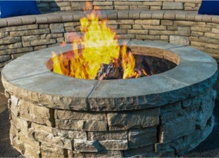 A custom built fire pit with a burning fire.