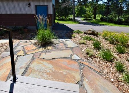 A flagstone patio installed in the landscape of a Black Brook client.