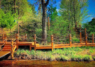 A long wooden newly constructed boardwalk on a lake front property.