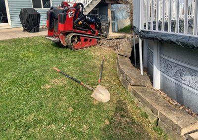 Professional landscaping equipment being used to prepare a lawn for landscaping features