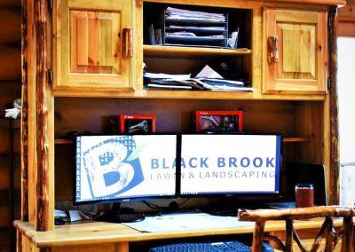 A desk and two monitors in the office of Black Brook Lawn & Landscaping