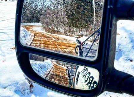 A snowy road that has been cleared by Black Brook Lawn & Landscaping.