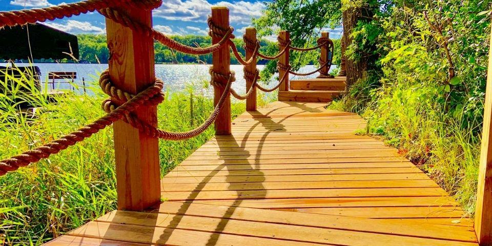 A wood and rope boardwalk leading to a lake.