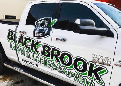 A Black Brook Lawn and Landscape work truck bearing the logo of the company